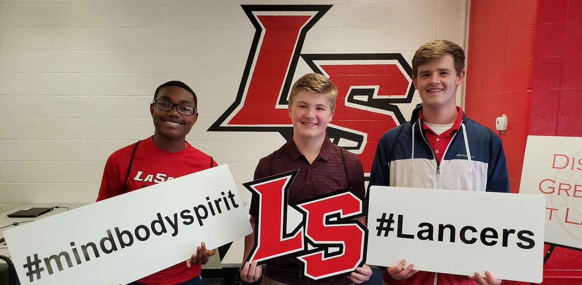 Three boys with signs